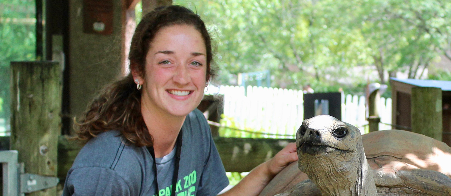 Simpson College graduate Emma Fleddermann with a tortoise at Blank Park Zoo.